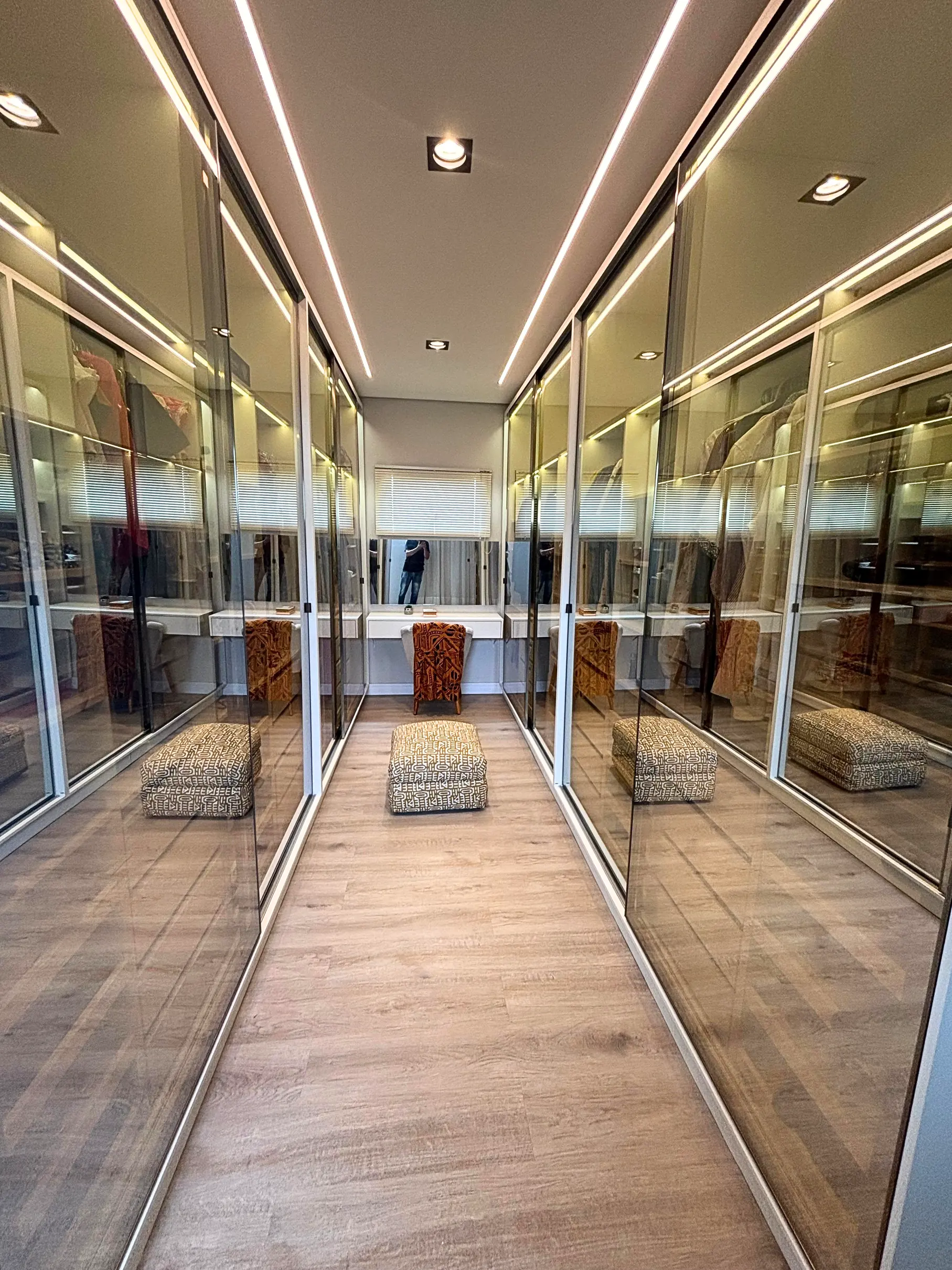 Closet planejado com vidro reflecta e iluminação embutida
