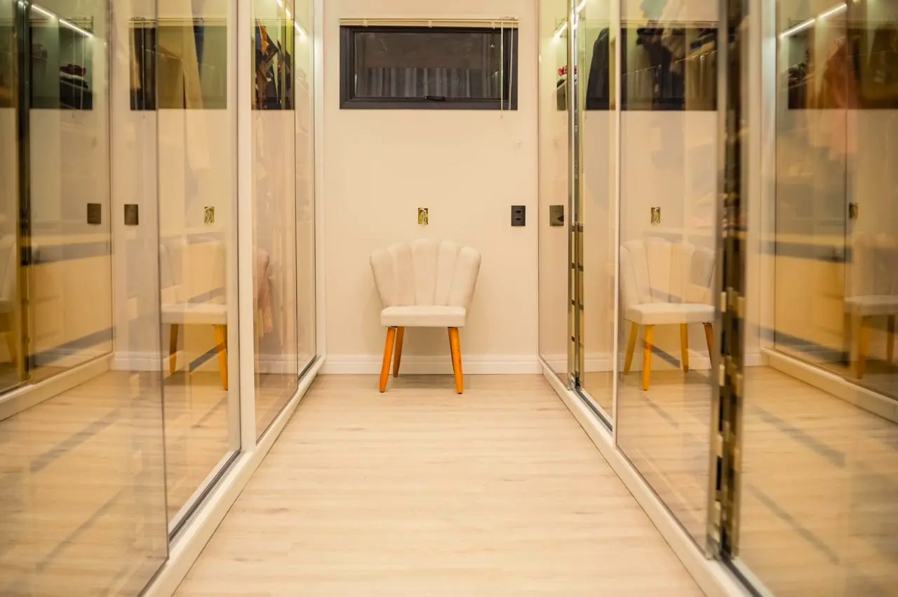 Closet claro planejado com portas de vidro